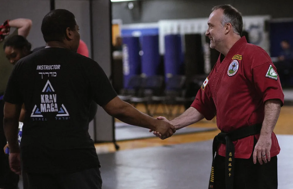 Headmaster Scott Gilbert congratulating an adult Krav Maga student