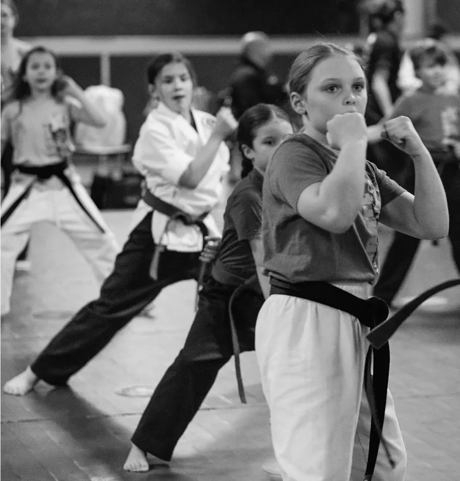 Young students holding fighting stances during belt testing