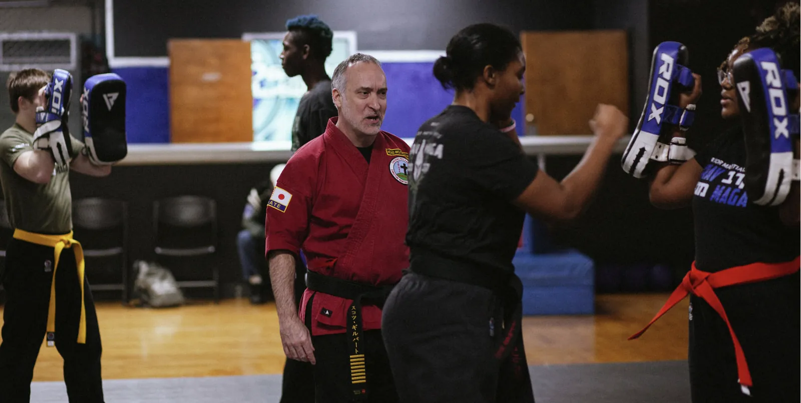 Adults training Krav Maga pad work with Headmaster Scott Gilbert