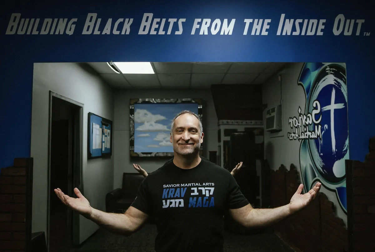Headmaster Scott Gilbert welcoming visitors under the Building Black Belts From the Inside Out sign